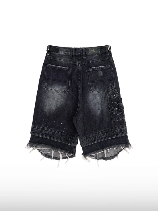 DistopionのGrunge Denim Shortsのバックフラットレイ画像。伝統的なバックポケット、右太もも裏のカーゴポケット、ウエスト右側の黒いブランドロゴパッチ、そして裾から激しくほつれ出た白いフリンジ糸のディテール。