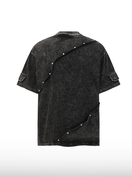 DistopionのShatter Point Rivet Teeのバックビュー。首元から裾へ向かってアシンメトリーに斜めに走る金属製スナップボタンのディテールと、立体的なカッティングが際立つ後ろ姿。
