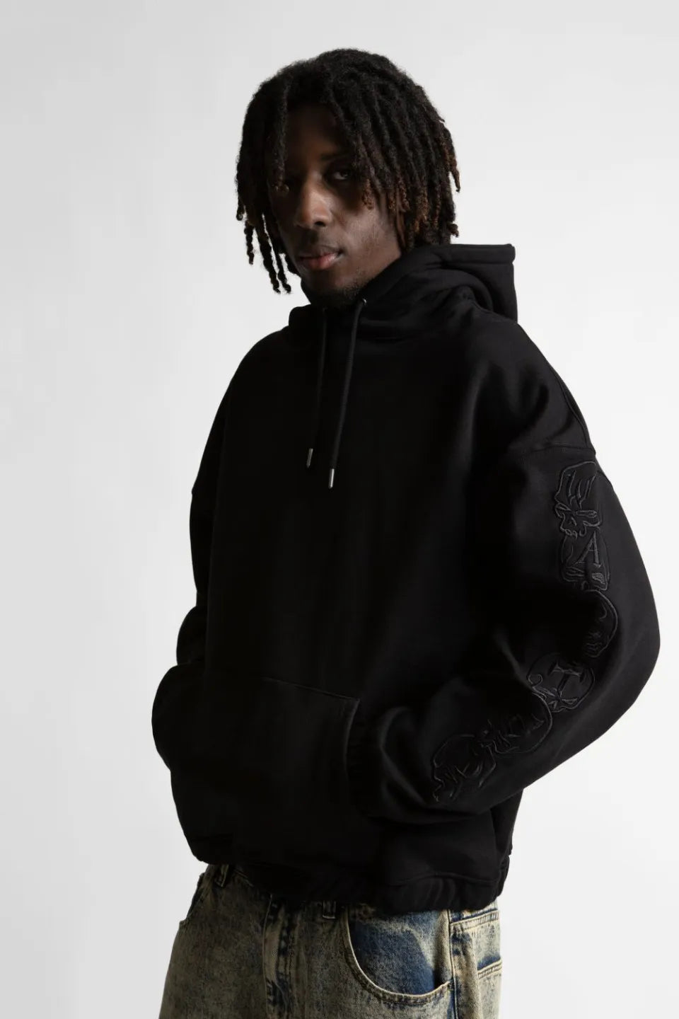 【WASTED PARIS】 BURY BOXY HOODIE (BLACK) 両袖の連続刺繍ディテールを強調した男性モデルのアップ画像
