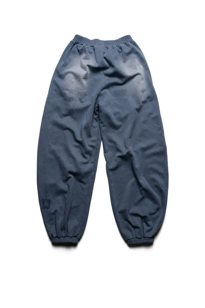 Racer WorldwideのBat Wing Sweatpantsのバックビュー。ヒップまわりの大胆なフェード（色褪せ）加工と、左裾付近のパッチワークがヴィンテージ感を漂わせる、ワイドシルエットの後ろ姿。