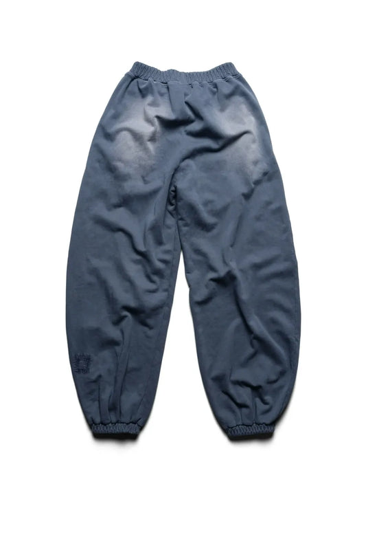 Racer WorldwideのBat Wing Sweatpantsのバックビュー。ヒップまわりの大胆なフェード（色褪せ）加工と、左裾付近のパッチワークがヴィンテージ感を漂わせる、ワイドシルエットの後ろ姿。