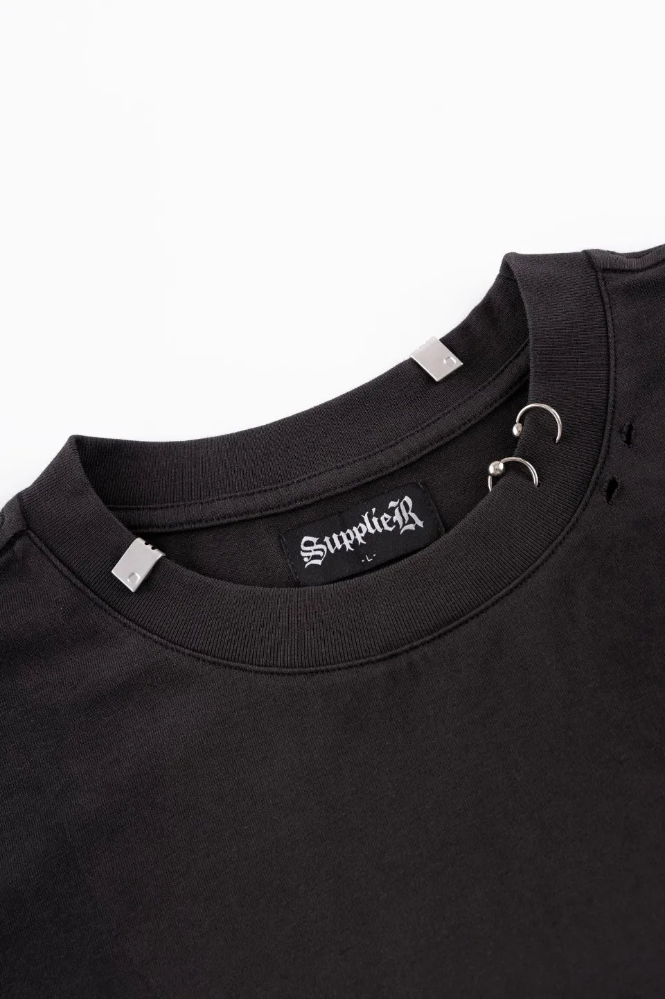 Pierced Tribal Bones Tee - black襟元のアップ。シルバーのリングピアスパーツとブランドプレート、首回りのクラッシュ加工のディテール。