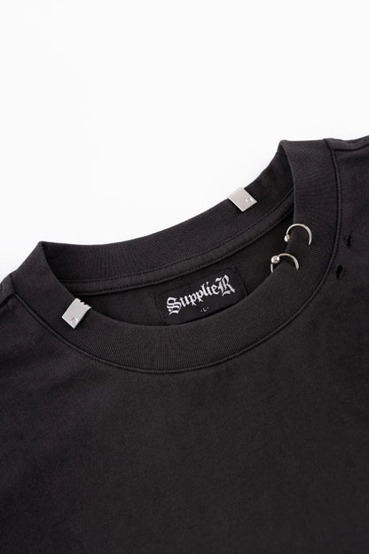 Pierced Tribal Bones Tee - black襟元のアップ。シルバーのリングピアスパーツとブランドプレート、首回りのクラッシュ加工のディテール。