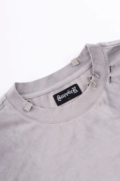 Pierced Tribal Bones Tee - gray襟元のアップ。シルバーのリングピアスパーツとブランドプレート、首回りのクラッシュ加工のディテール。