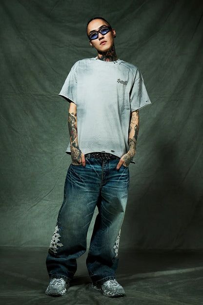 SUPPLIER Pierced Tribal Bones Tee - GRAY の着用画像。ボックスシルエットを生かしたベルト見せのコーデ。パンツはクロスパッチ付きのデニム。