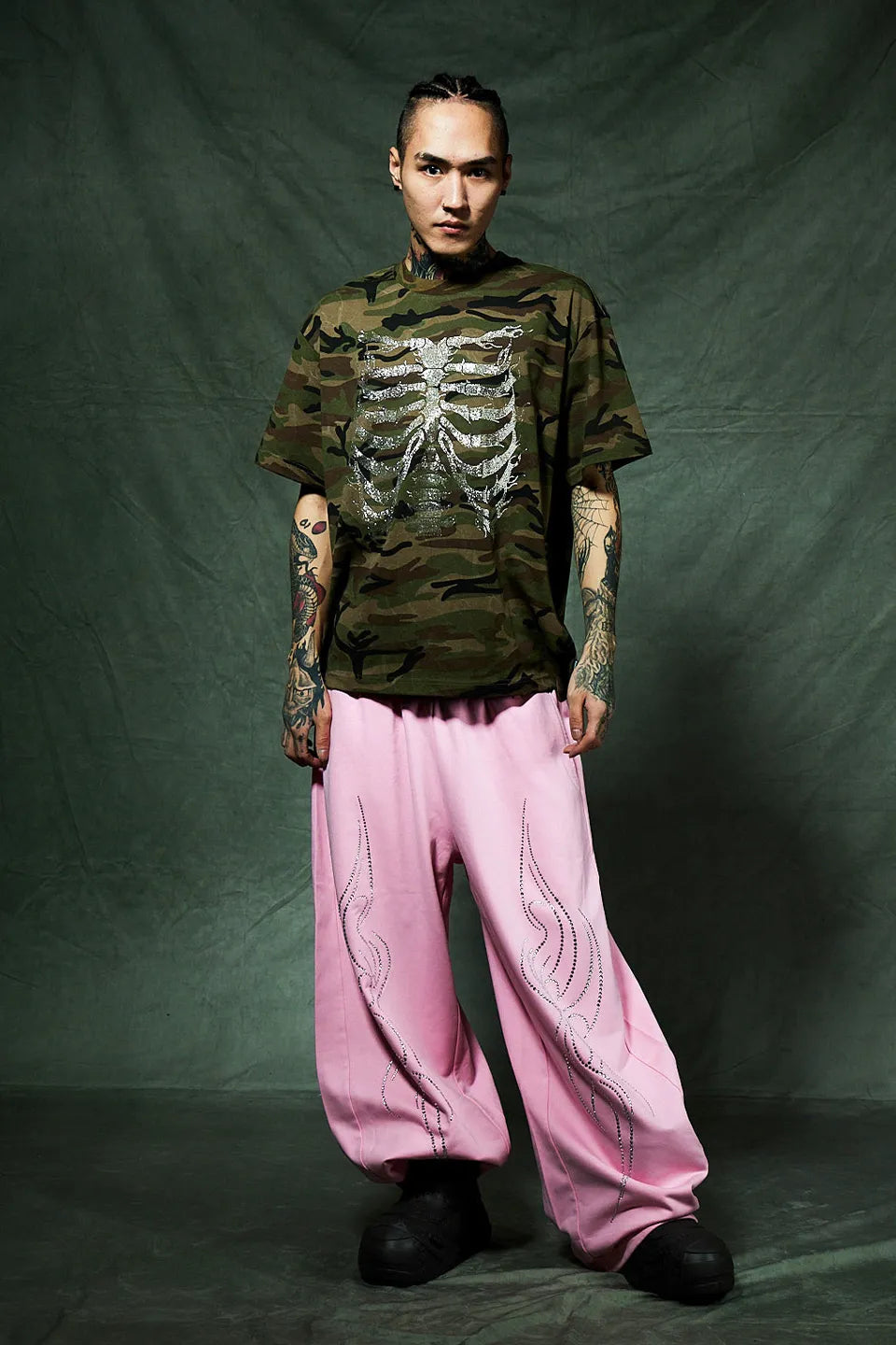 SUPPLIER Rhinestone Fire Bone Tee - KAHKIの着用画像。ピンクのスエットバギーパンツとブラックのブーツを組み合わせたコーデ。