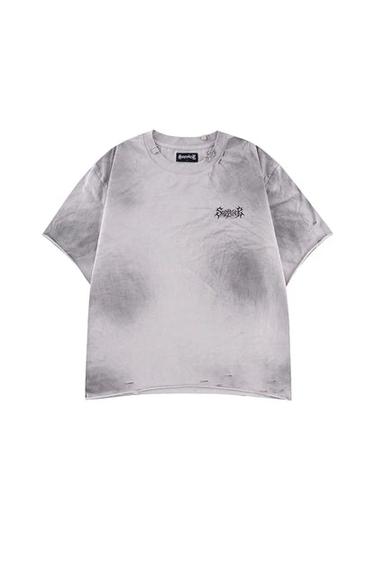 Pierced Tribal Bones Tee - Gray の正面。フェード加工されたボディ、首元のピアスとプレート装飾、切りっぱなしの裾が確認できるカット。