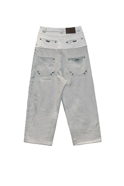 Dray Double-Layered Sweatpants Thought We Friendsのグレーカラー平置き背面画像。レザーパッチとサイドのラインストーンロゴ、ルーズなバギーシルエット。