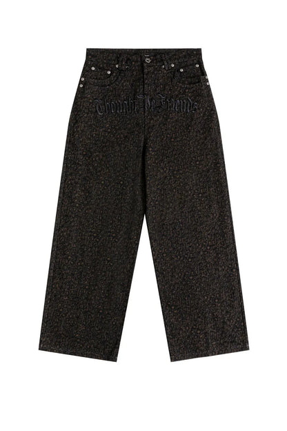 Thought We FriendsのLuciusバギーデニムパンツの前面。腰回りに「Thought We Friends」とゴシック調の黒い刺繍が施された、ダークトーン総柄のワイドデニム。