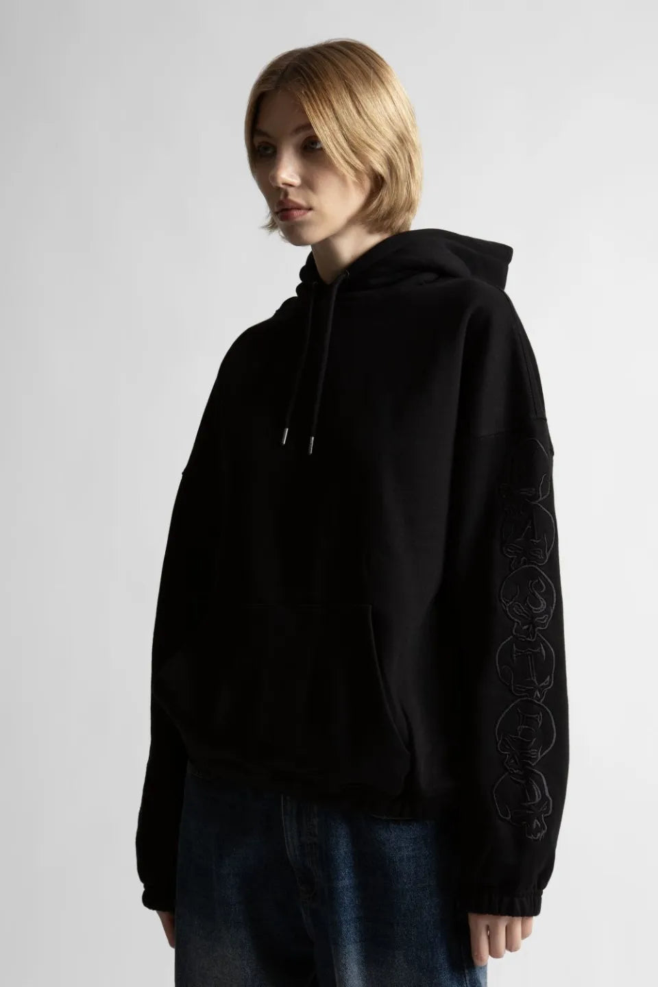 【WASTED PARIS】 BURY BOXY HOODIE （BLACK） 袖グラフィック刺繍とボクシーなフィット感を魅せる女性モデルのアップ画像