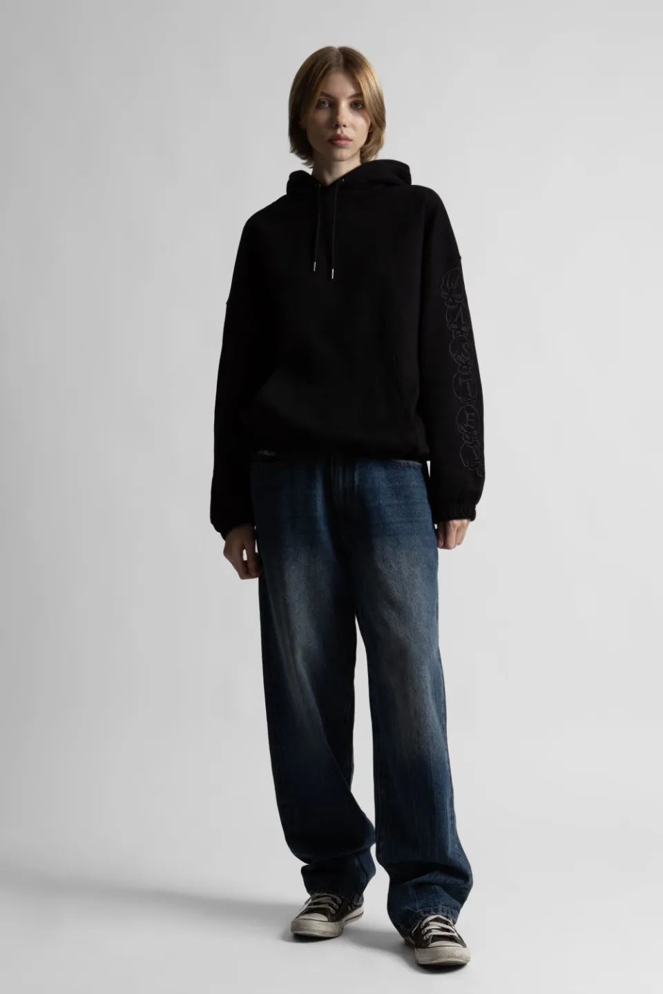 【WASTED PARIS】 BURY BOXY HOODIE （BLACK） ワイドデニムとスニーカーを合わせた女性モデルのストリートスタイル画像